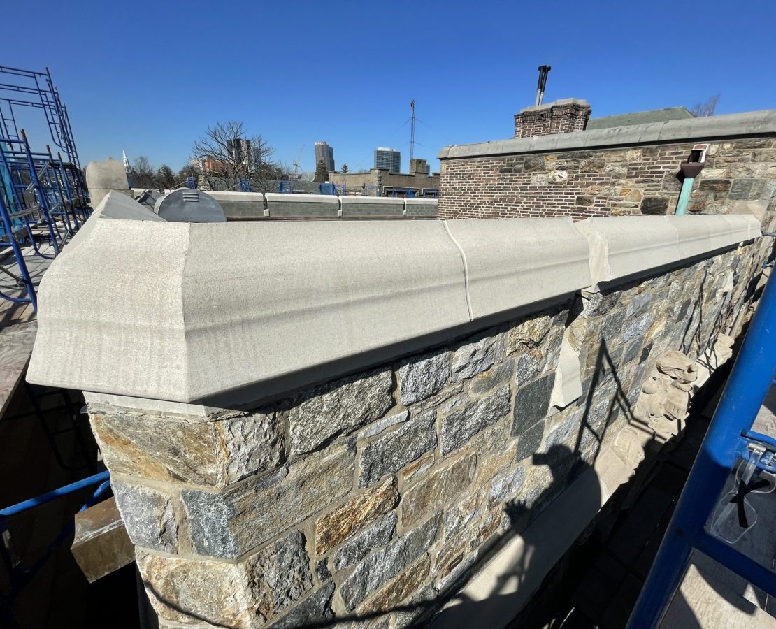 Cast stone replaces limestone at a parapet.