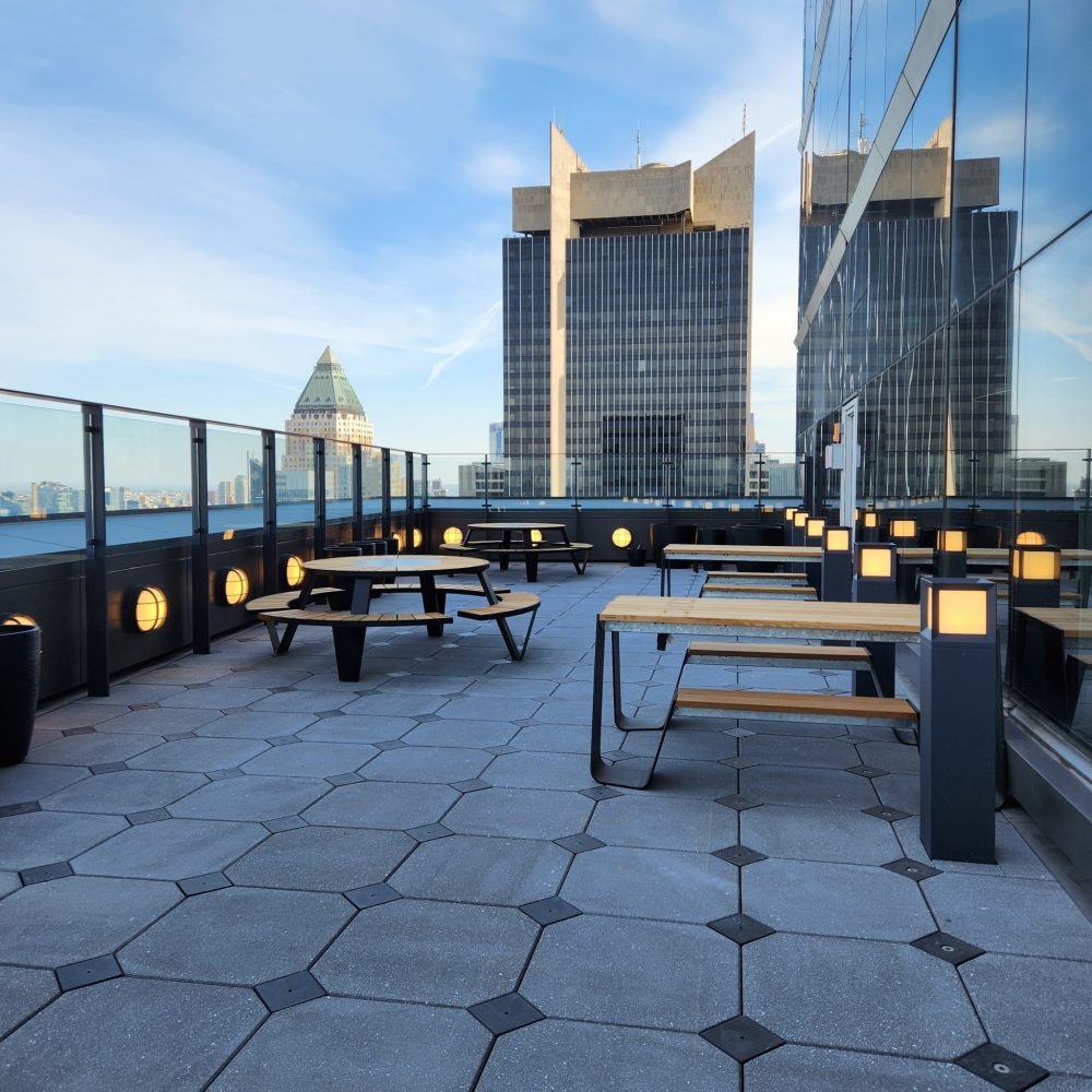 Roku roof after renovation with picnic tables, lighting, and attractive pavers