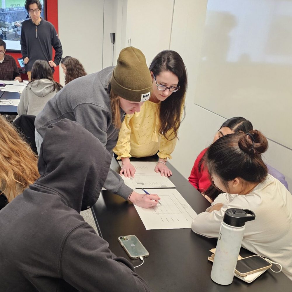 Kristen Anderson guides students through an architecture activity with the ACE Mentor Program
