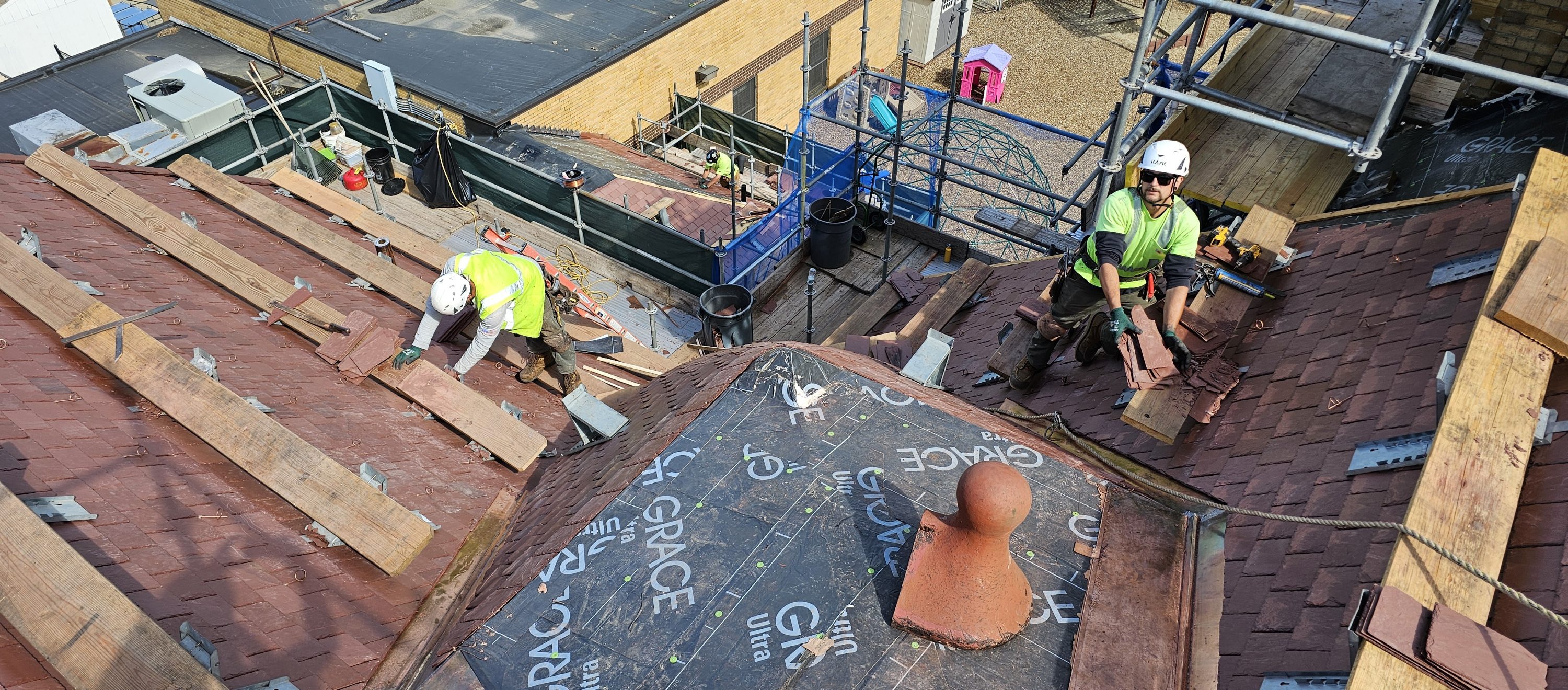 Slate roof replacement, showing construction workers on site