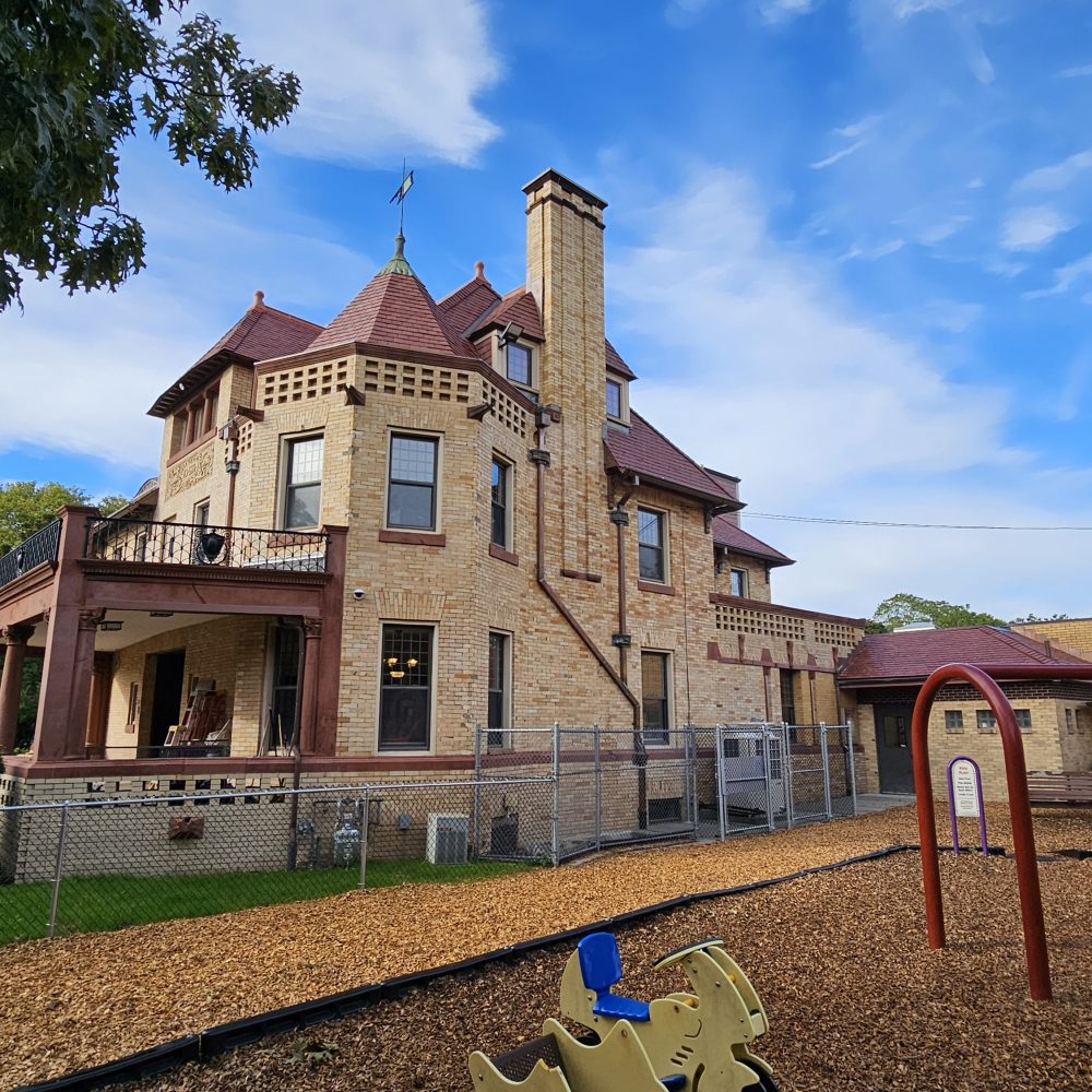Romanesque historic community center with adjacent playground