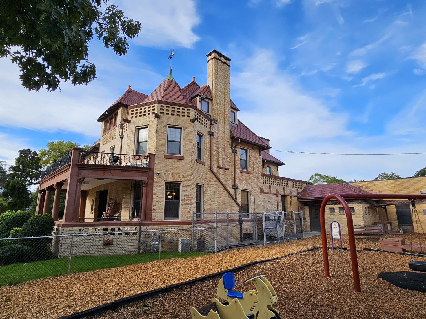 Romanesque historic community center with adjacent playground