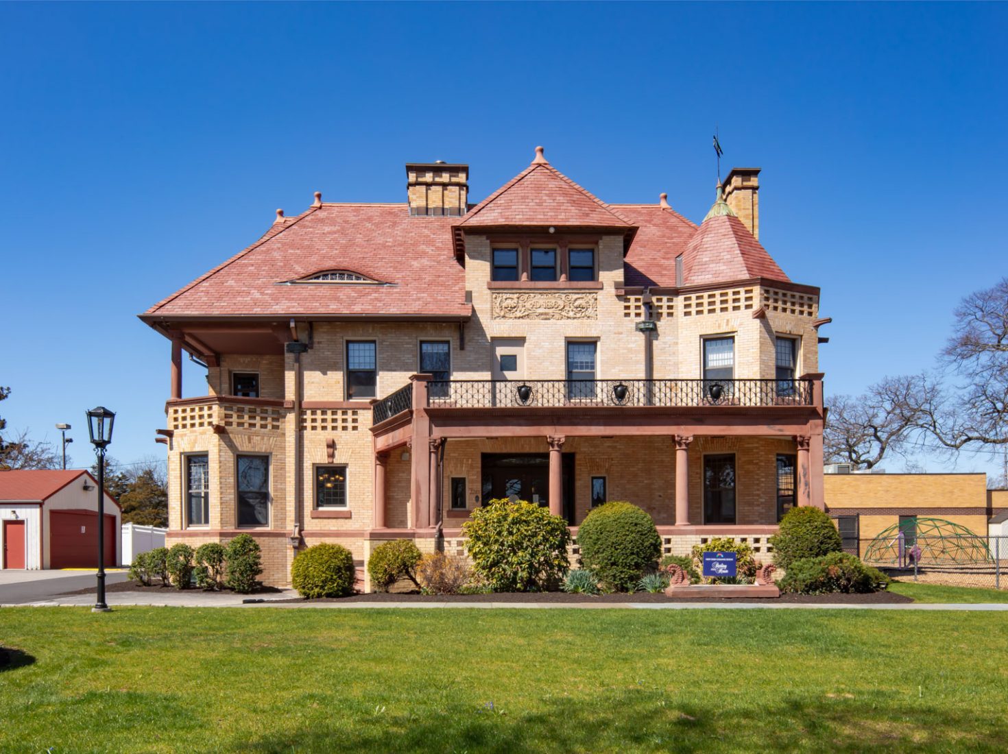 Romanesque building with gabled roofs and wraparound porch