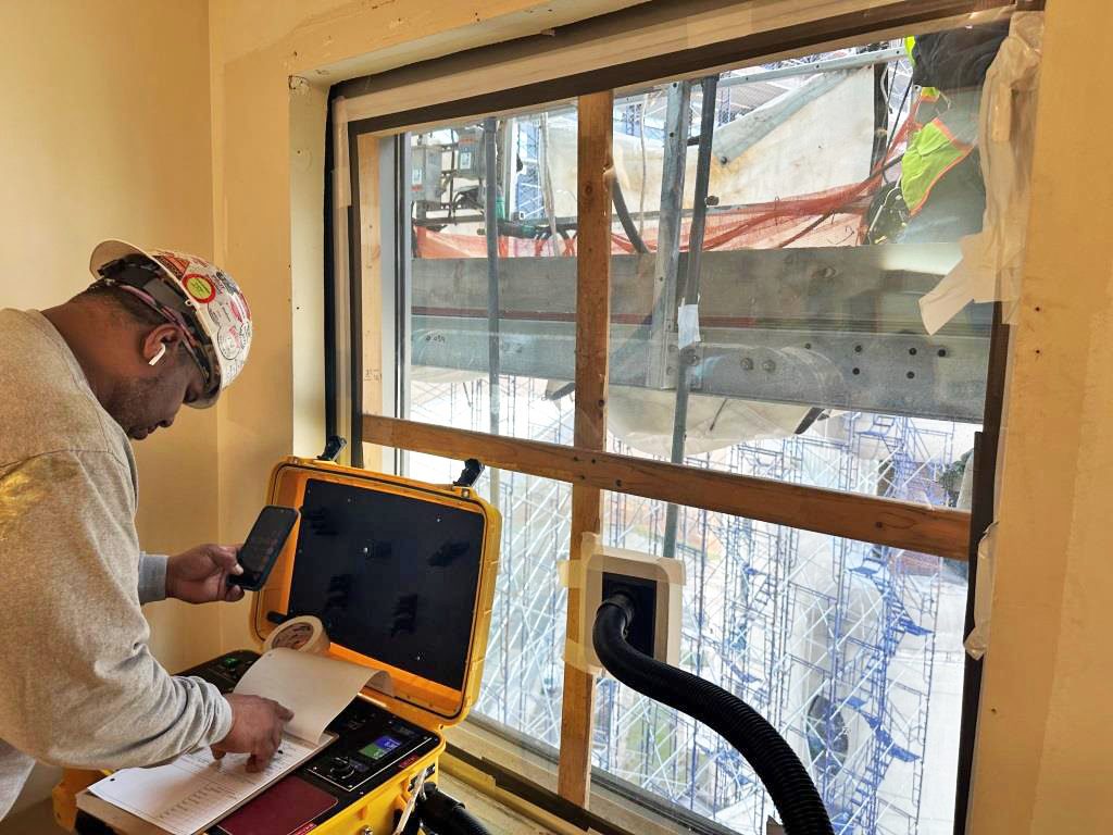 A technician runs performance tests on a newly installed window.