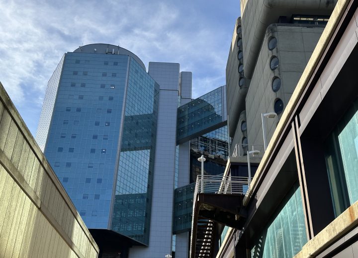 View from ground up of midcentury modern building with glass and concrete facades