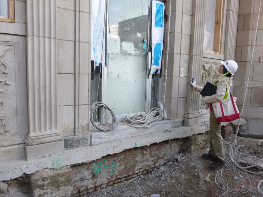 A design professional examines a historic facade during rehabilitation.