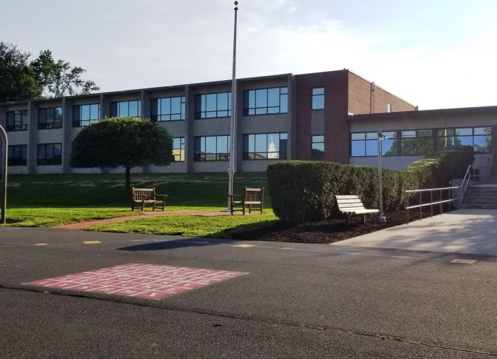 A grade school with recess area at the foreground, showcasing new windows