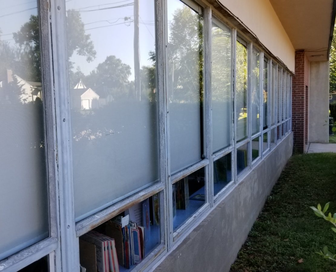 Aging metal-framed windows at a one-story grade school
