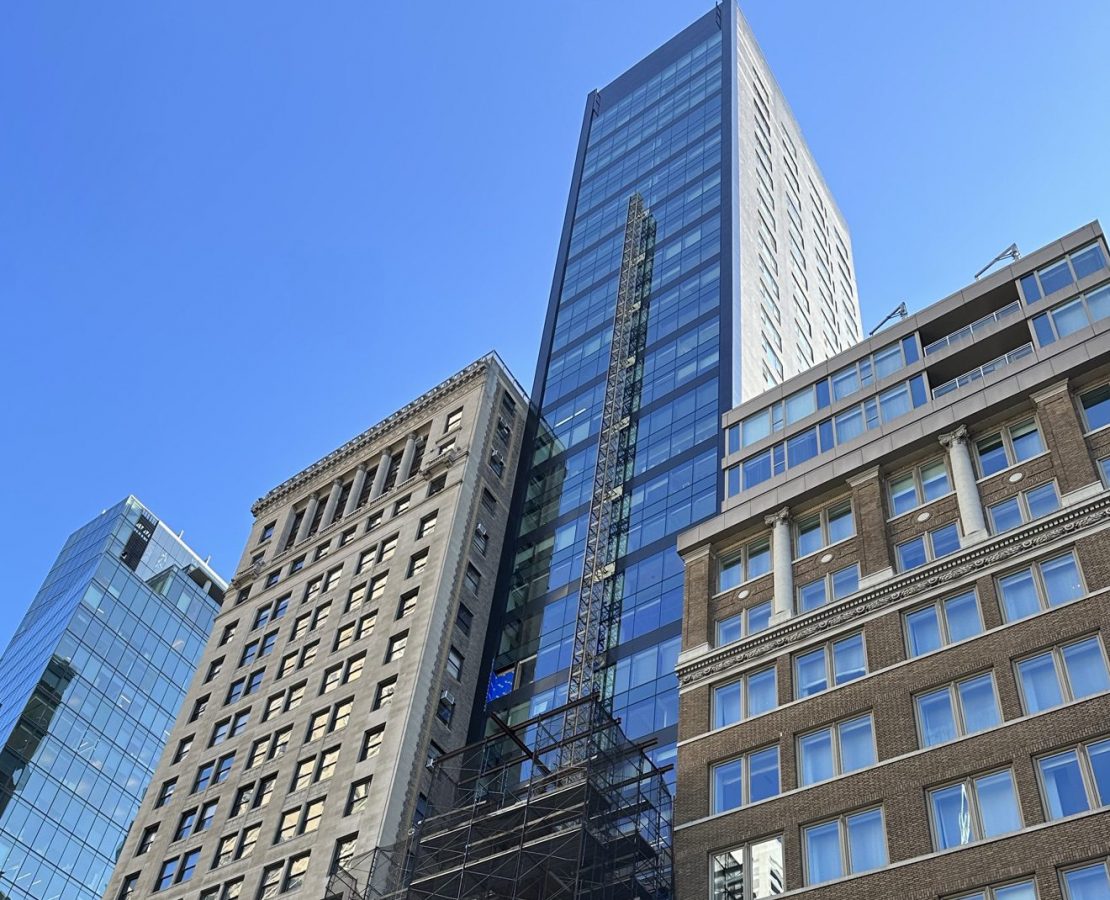 A high-rise residential tower in New York with a glazed curtain wall facade, during rehabilitation
