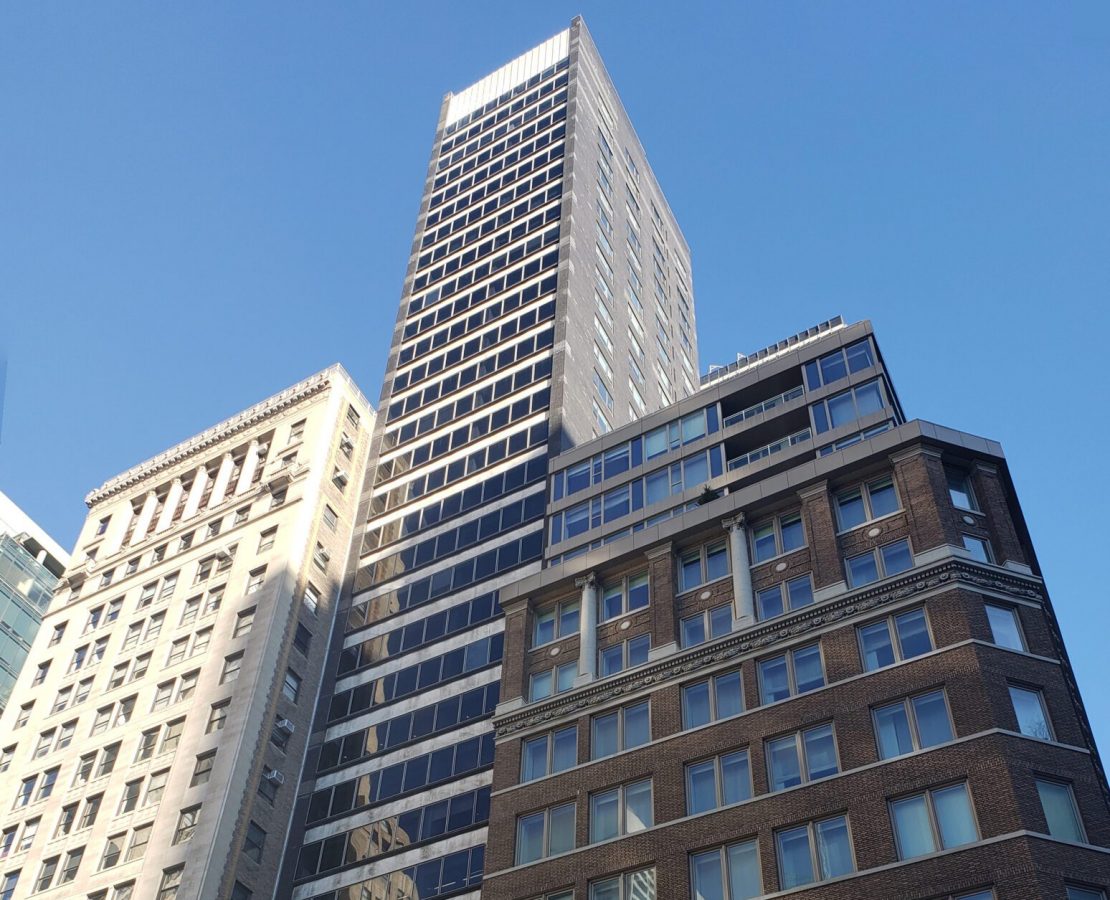 A high-rise residential tower in New York with a glazed curtain wall facade, prior to rehabilitation
