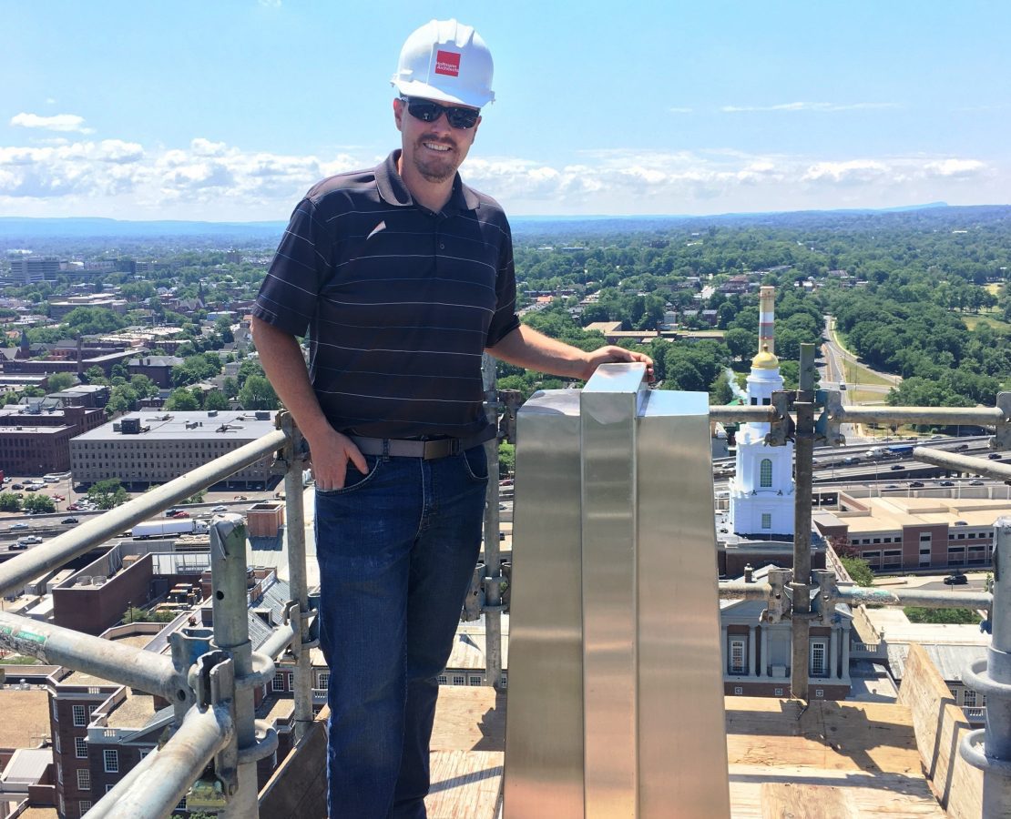 Architect Ben Robinson in a hard hat atop a cathedral