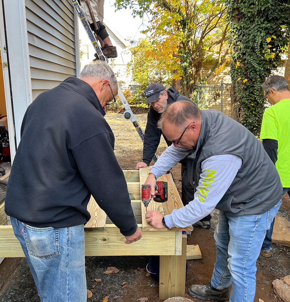 Two people work to build a porch on a Habitat for Humanity home in New Haven.