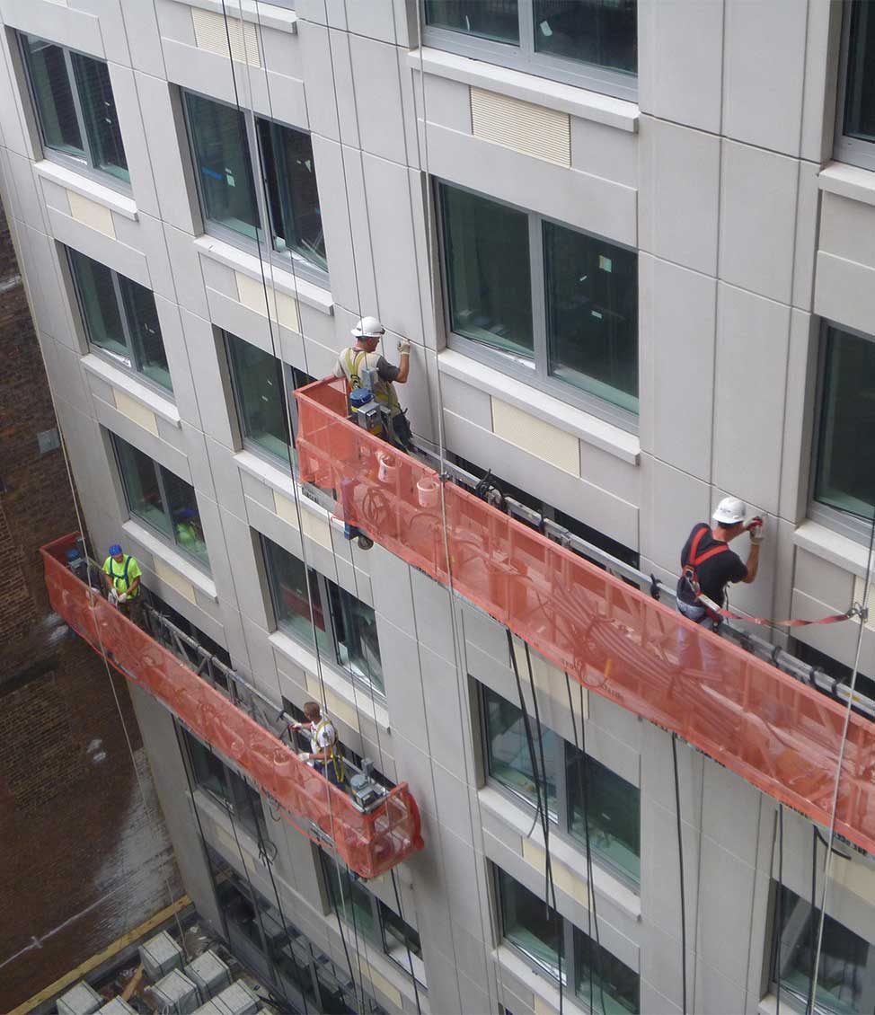Construction workers working on the exterior of a building