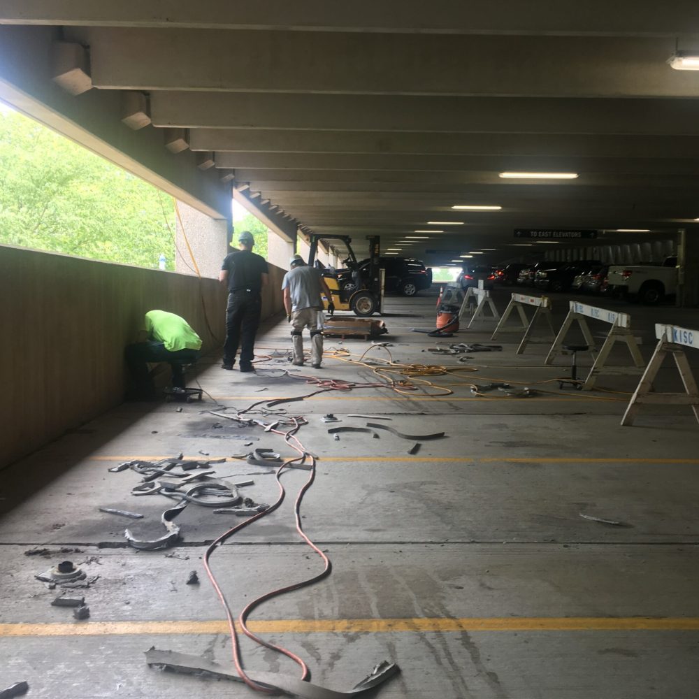 Contractors undertaking removal and replacement of sealant joints in a parking garage