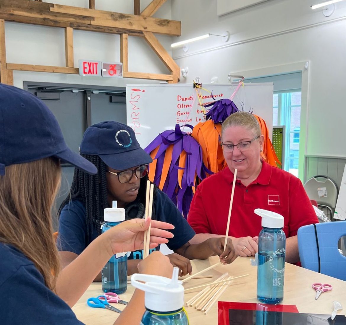 Students and an instructor at a table working with architectural models