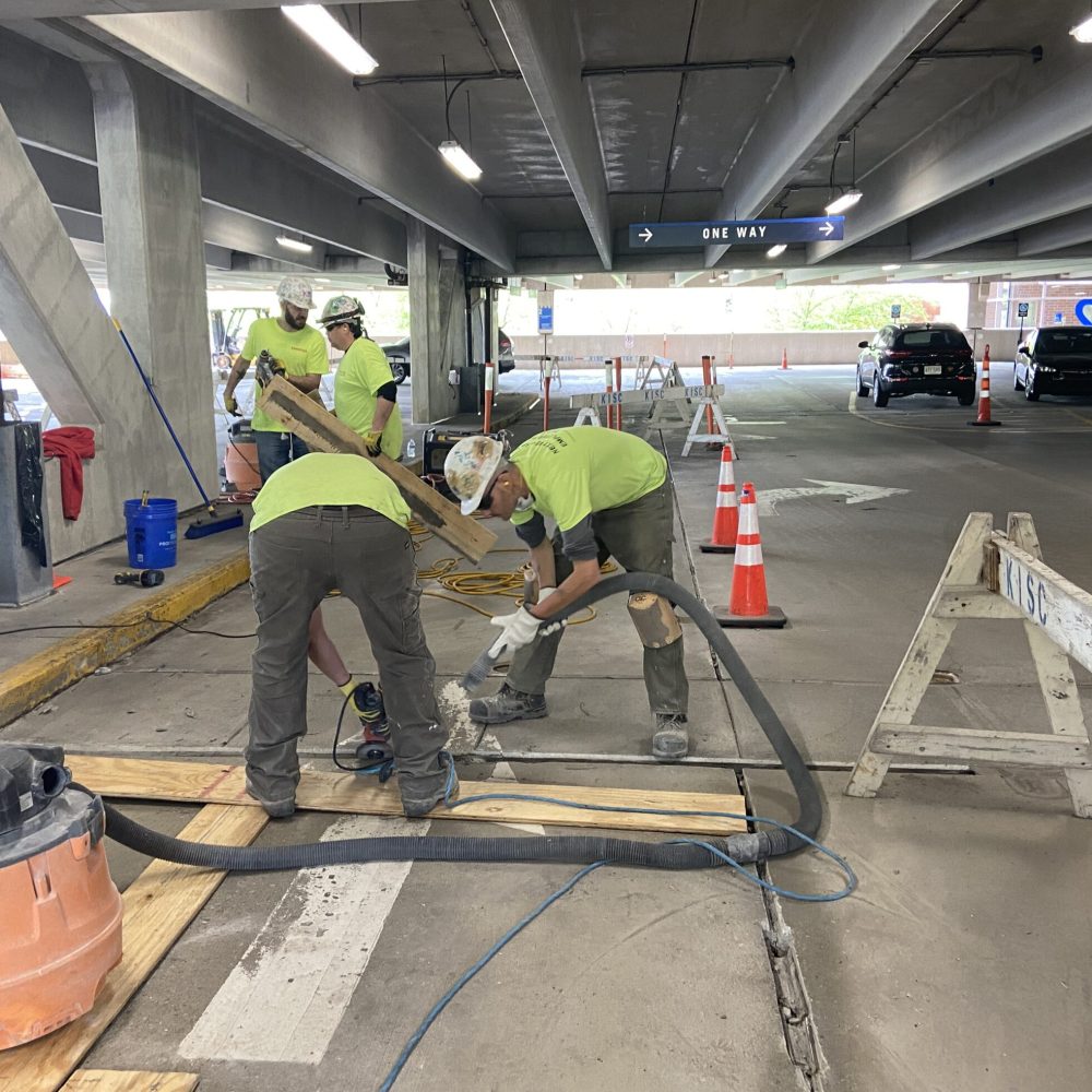 Construction workers completing a garage repair program, including concrete repair and replacement of sealant and expansion joints.