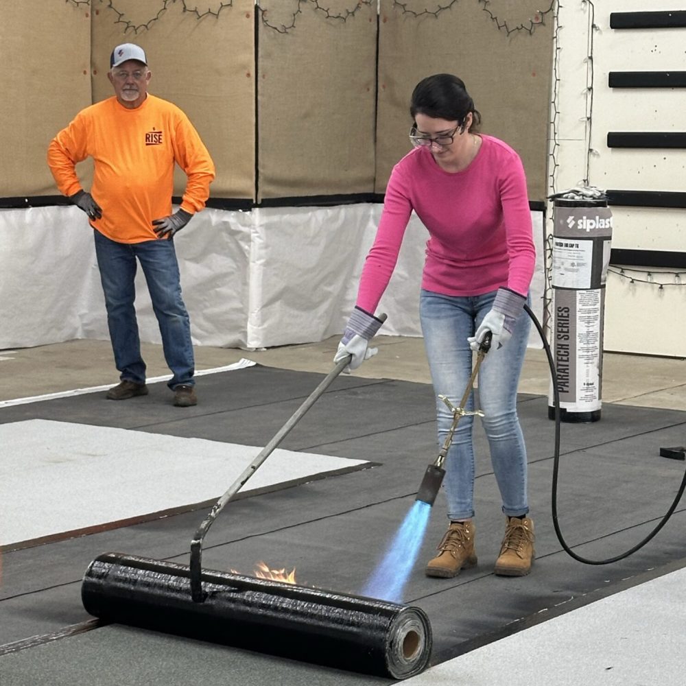 Kristen Anderson installing torch-applied roofing
