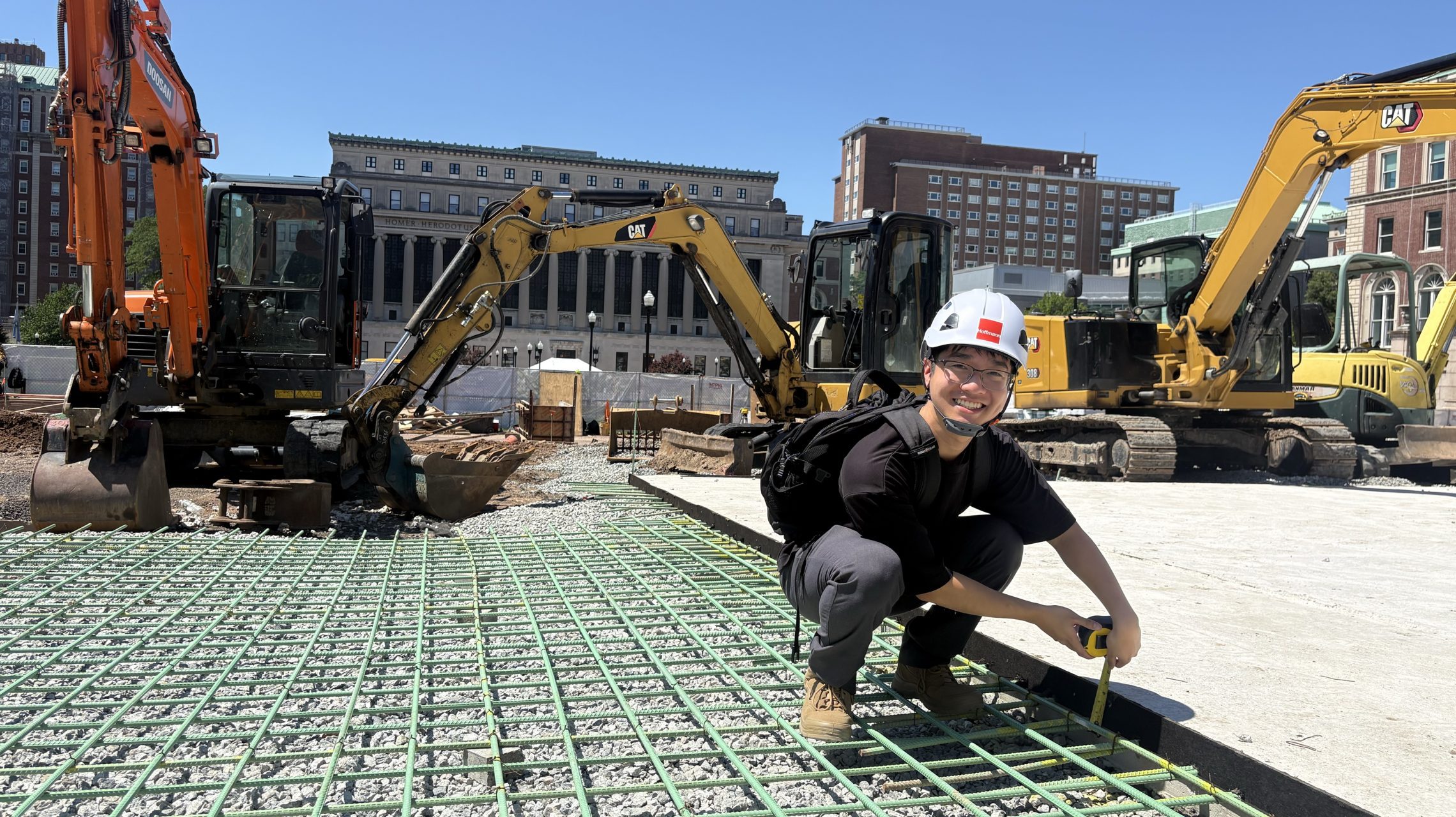 A design professional takes measurements during a plaza installation