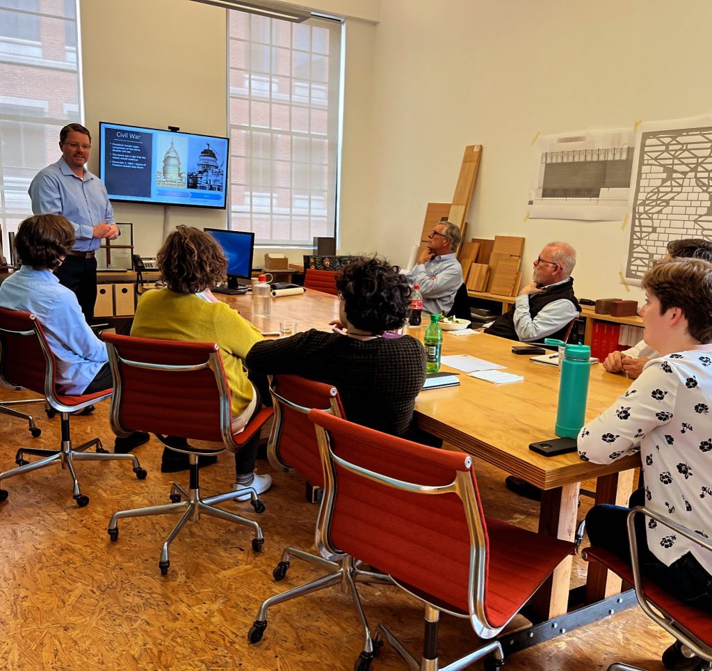Architect Ben Robinson delivers a presentation to a conference room of professionals