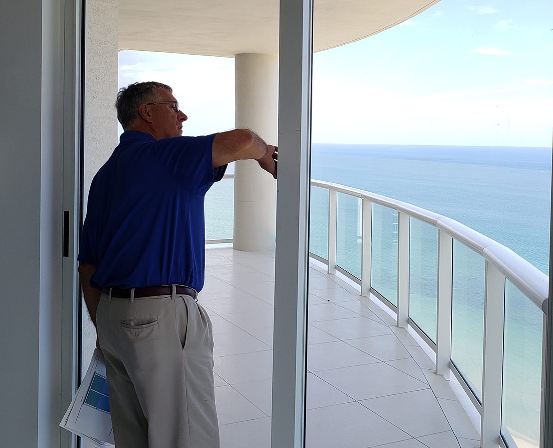 Architect Russell Sanders investigates a sliding glass door to a terrace